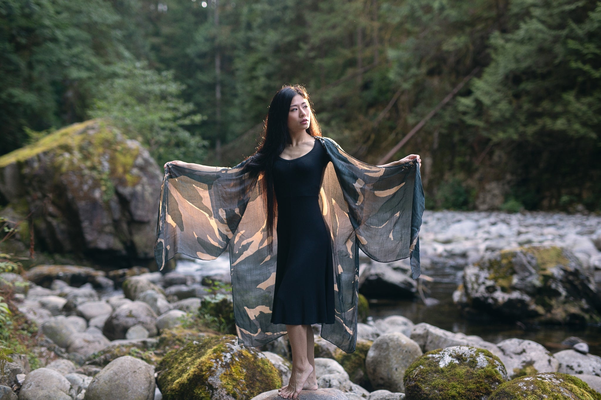 woman standing on rock wearing long grey mosaic print beach kimono and black bamboo dress, Shop T.K.S