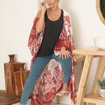 woman wearing white and red floral beach cover up with jeans and black tank top