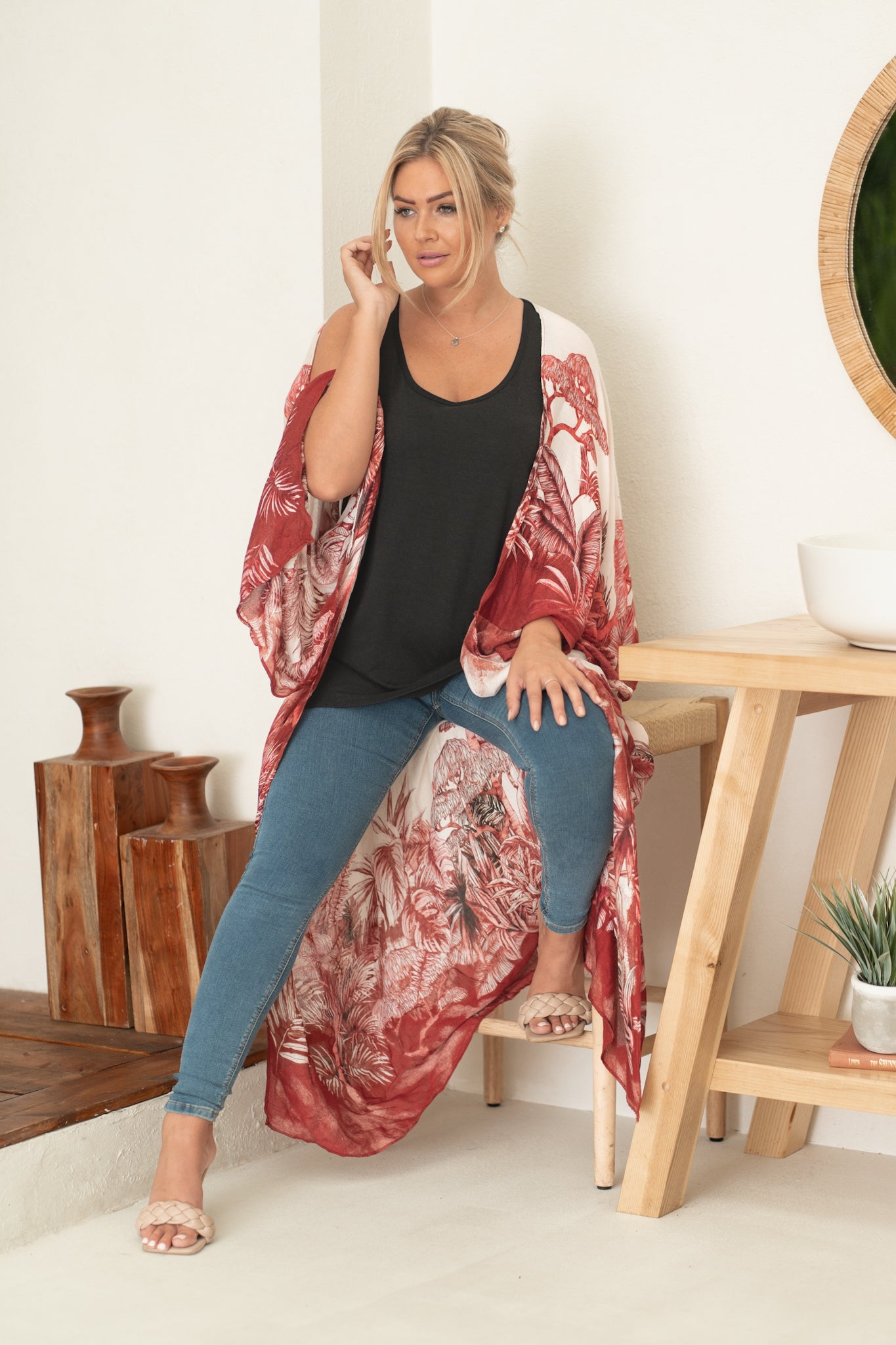 woman wearing white and red floral beach cover up with jeans and black tank top