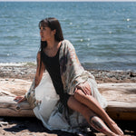 women's long floral beach cover up in white sitting on tree log