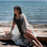 women's long floral beach cover up in white sitting on tree log