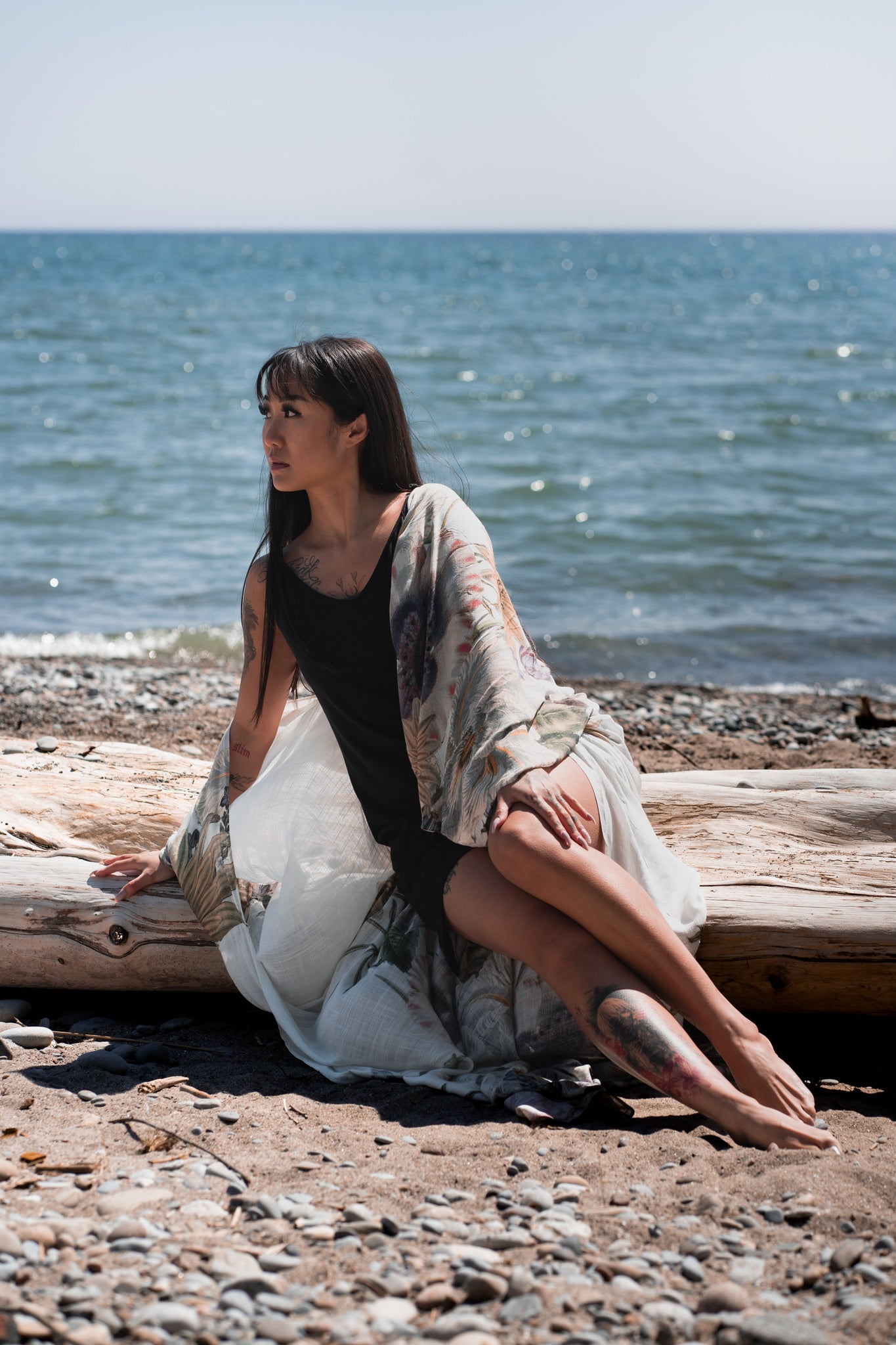 women's long floral beach cover up in white sitting on tree log