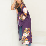 Woman wearing purple and floral robe leaning on stairs staring at camera
