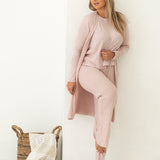 Woman looking away from camera wearing pink lounge set with white background