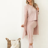 Woman looking away from camera wearing pink lounge set with white background