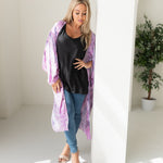 Woman wearing purple tie dye beach cover up, Shop TKS, looking down