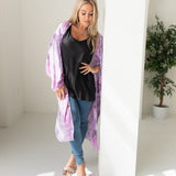 Woman wearing purple tie dye beach cover up, Shop TKS, looking down