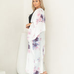 Woman staring at camera wearing white and floral chelsea beach cover up, Shp T.K.S