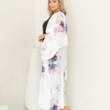 Woman staring at camera wearing white and floral chelsea beach cover up, Shp T.K.S