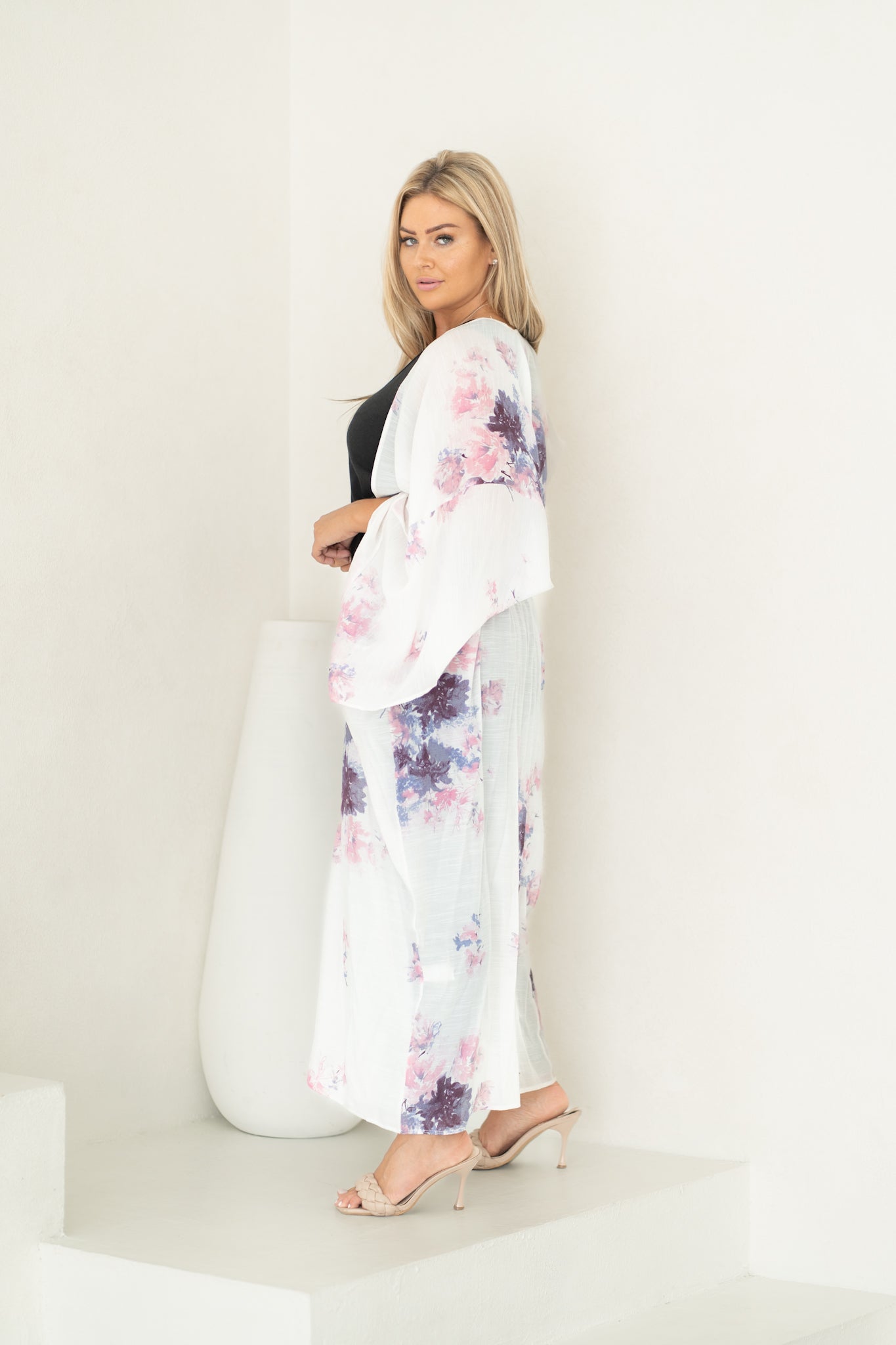 Woman staring at camera wearing white and floral chelsea beach cover up, Shp T.K.S