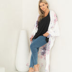 Woman sitting wearing white floral beach cover up, bamboo tank top and jeans, Shop T.K.S
