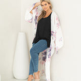 Woman standing with hand in her hair wearing white floral chelsea beach cover up and black bamboo tank and jeans, Shop T.K.S