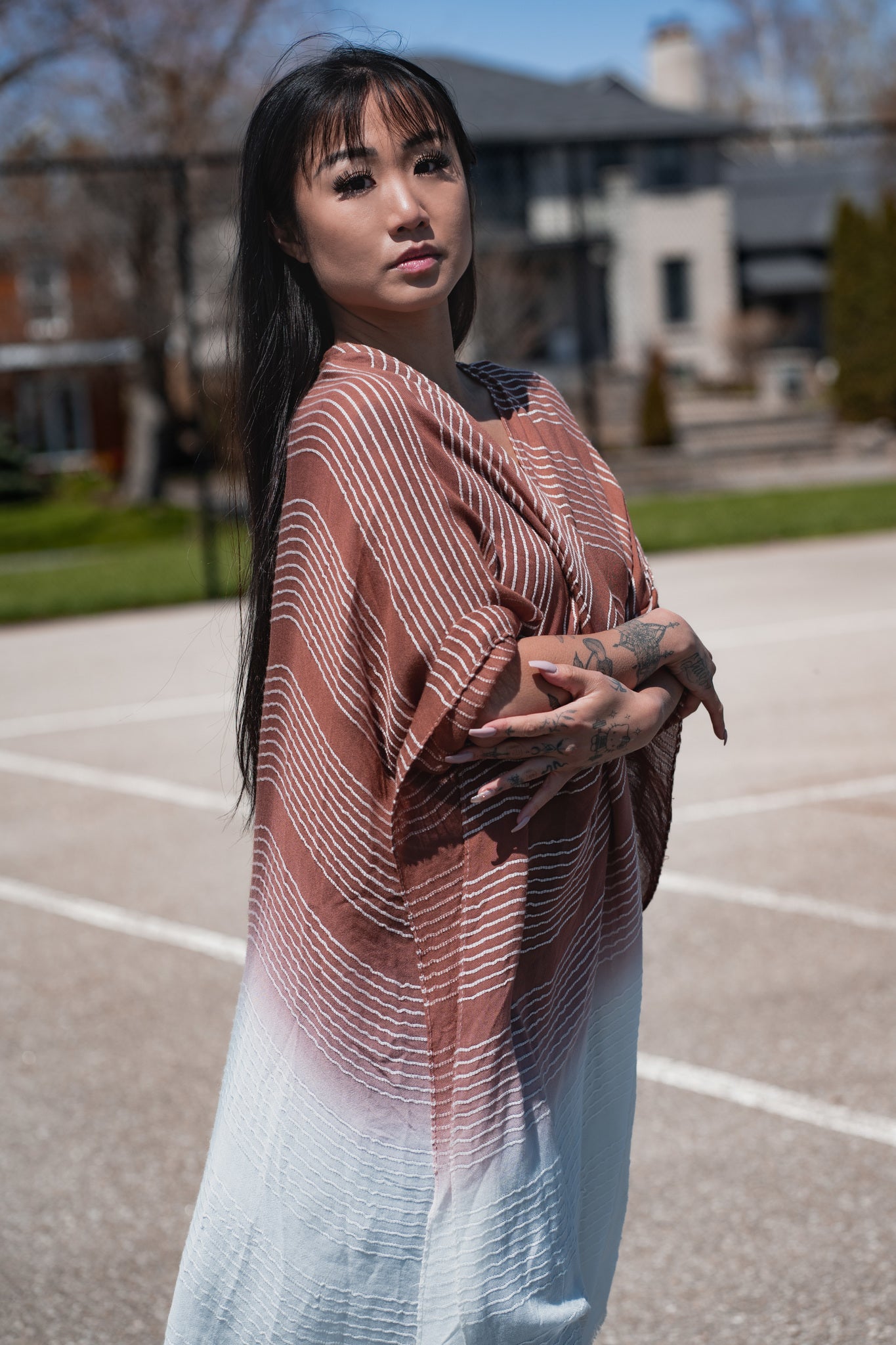 Woman wearing burnt orange and white striped beach cover up, Shop TKS