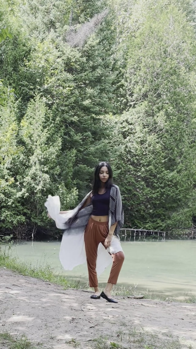 Video of model wearing black and white striped beach cover up with orange lounge pants and bamboo crop top, Shop T.K.S