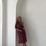 video or woman posing in pink and green kimono style robe