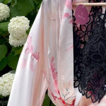 Video of light pink and floral robe with black lace crop top lingerie flowing in the wind with hydrangeas in the background