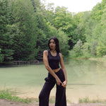Woman standing in front of pond wearing black lounge pants
