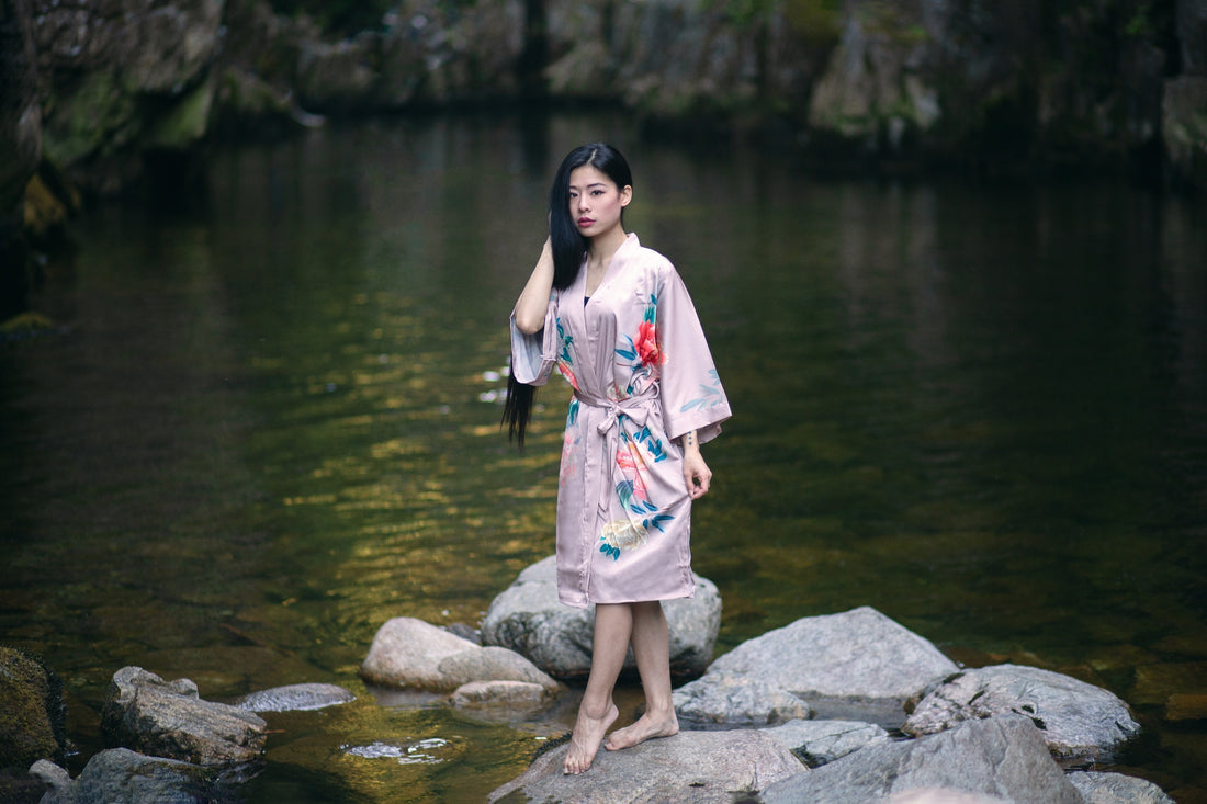 Woman wearing pink floral short robe standing on rock in the water, Shop T.K.S