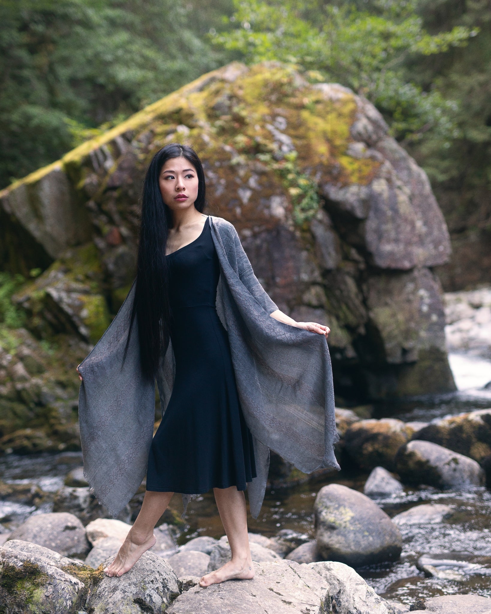 Woman standing in front of big rock wearing grey anna beach cover up and black bamboo dress staring away from camera, Shop T.K.S