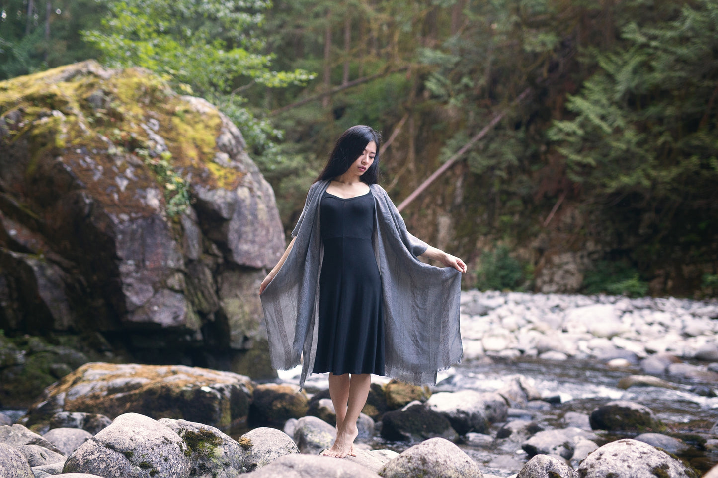 Woman standing in front of big rock wearing grey beach cover up and black bamboo dress, Shop T.K.S