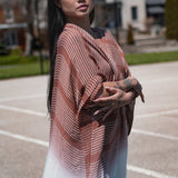 Woman wearing burnt orange and white striped beach cover up, Shop TKS