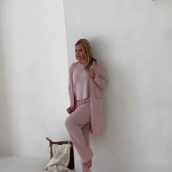 video of woman in pink loungewear with white background