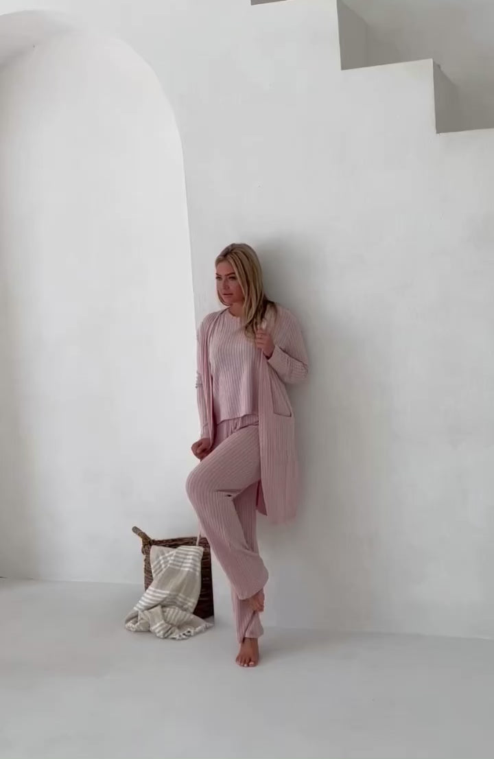 video of woman in pink loungewear with white background