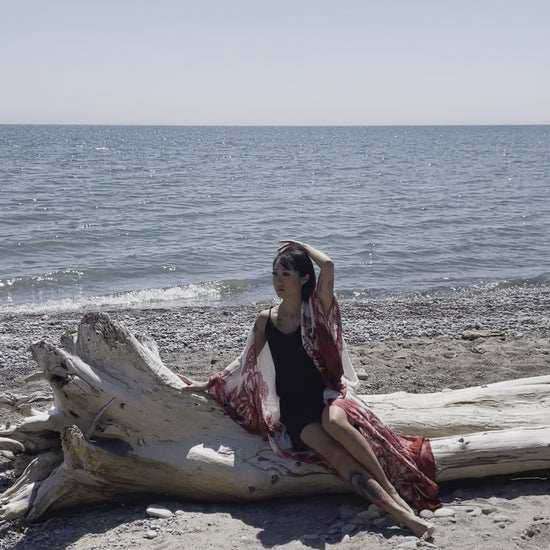 video of woman sitting on log wearing long white red floral beach cover up shop tks